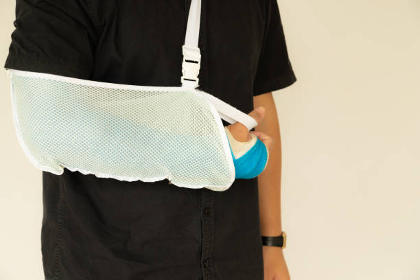 istock Broken hand injury, Asian man with hand operation with pressure bandage with copy space, Hand with wrapped plaster and arm sling. 1158645706