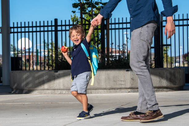 学校に戻って、小さな男の子は、学校の最初の日にリンゴを持っています - little boys preschooler back to school backpack ストックフォトと画像