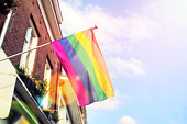 Rainbow LGBT flag against the blue sky, symbol of tolerance and acceptance, diversity, hope and longing. Flag LGBT hovering in the wind.