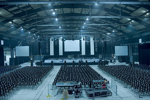 Dark blue-toned large empty auditorium hall A music arena just after the stage has been set up and before the equipment is set up political rally photos stock pictures, royalty-free photos & images