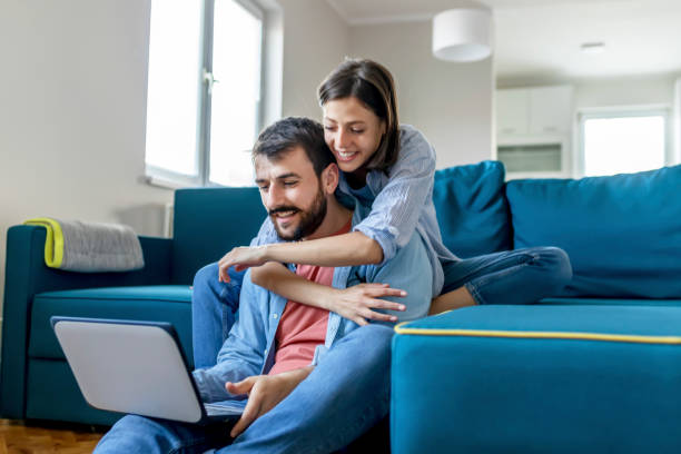 istock Cheerful couple searching something on laptop at home 1158654964