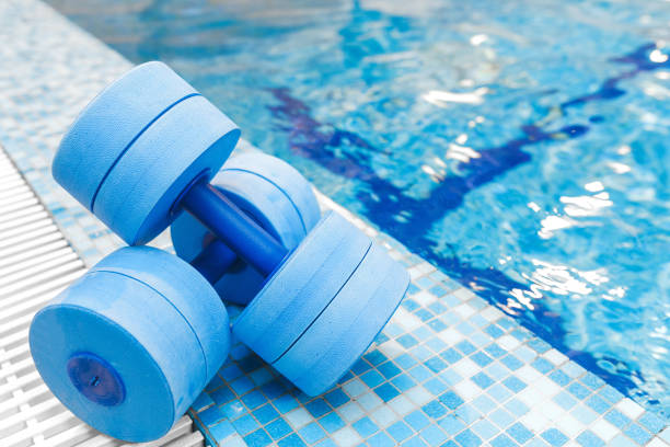 attrezzature manubri per sport aerobici in acqua vicino alla piscina - nobody man made equipment man made object foto e immagini stock