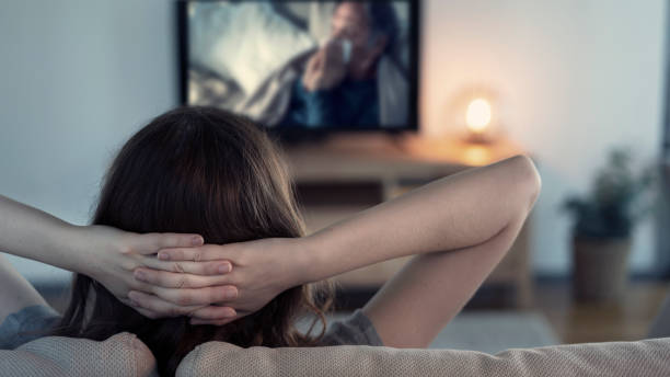 istock Woman watching tv at home 1158668179