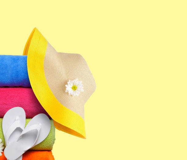 istock Sun Hat And Beach Towels On Yellow Background 1158670927
