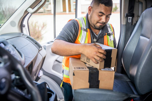 配達人は、車両からパッケージを取ります - postal worker delivering mail post office ストックフォトと画像
