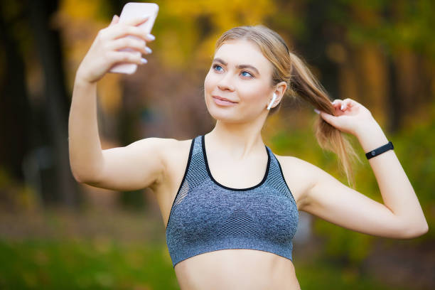 istock Sportswoman taking a break after workout and using phone outdoors 1158671753