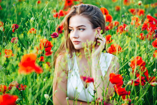 istock Beautiful young girl in poppy fields at sunset. 1158672893