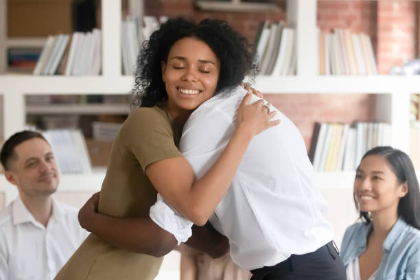 diversas personas abrazan la empatía en el asesoramiento grupal - couple dependency standing men fotografías e imágenes de stock