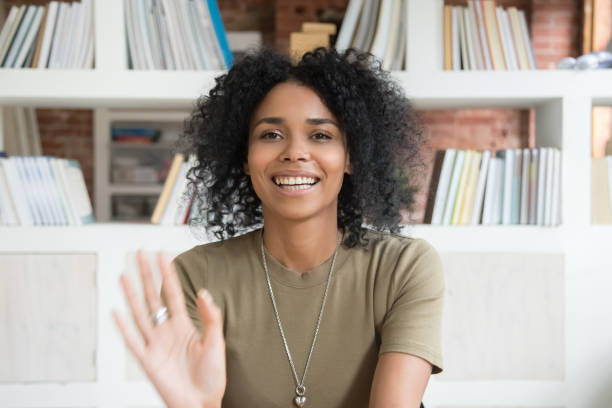 istock Smiling black woman waving talking on webcam 1158676693