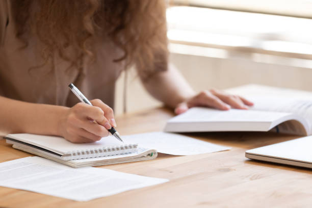 istock Close up of female student study using handbooks writing notes 1158676710