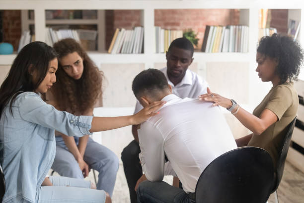 istock Diverse people hug support depressed man at group therapy 1158676767