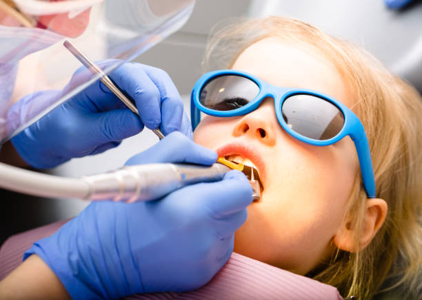 niña que recibe el procedimiento de llenado dental en la clínica dental pediátrica - handpiece fotografías e imágenes de stock