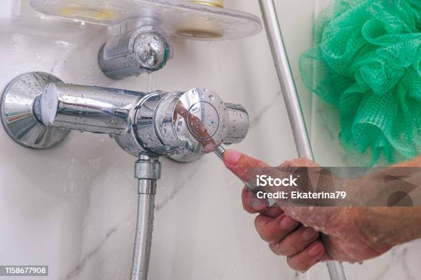 Person Hand Using Faucet In The Shower Close Up Stock Photo - Download Image Now - Shower, Closing, Faucet