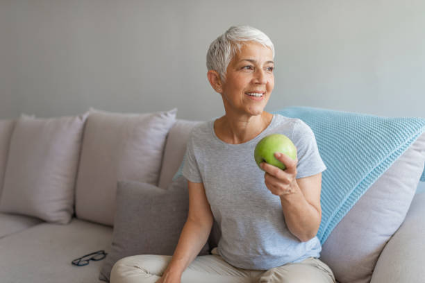istock Healthy mid age woman holding apple closeup 1158679018
