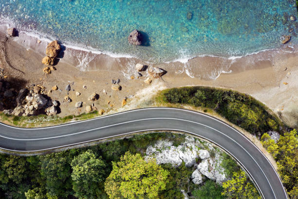 carretera costera acercándose a una playa, vista desde arriba - coastline fotografías e imágenes de stock