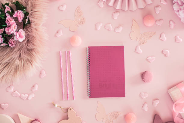 istock Notebook, pencil, decorations, and macaroons on rose background 1158682395