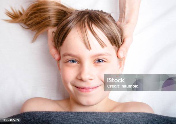 Girl Receiving Osteopathic Treatment Of Her Head In Pediatric Clinic Stock Photo - Download Image Now