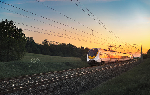 Modern German train traveling at sunset