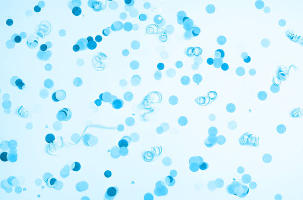 Blue background with many round multicolored confetti.