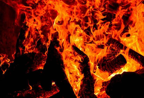istock Charred wood and bright flames on dark background 1158686172