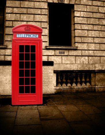 View of four Old red vintage telephone boxes in Cornwall, UK