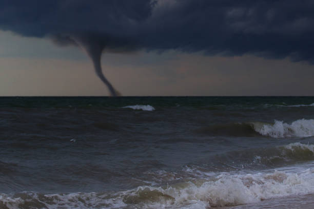 istock A tornado taring across a deserted beach on ocean 1158692311