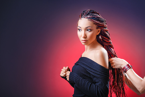 Colorful hair braids with kanekalon Zizi in the hands of a hairdresser, creativity and fashionable hairstyle concept