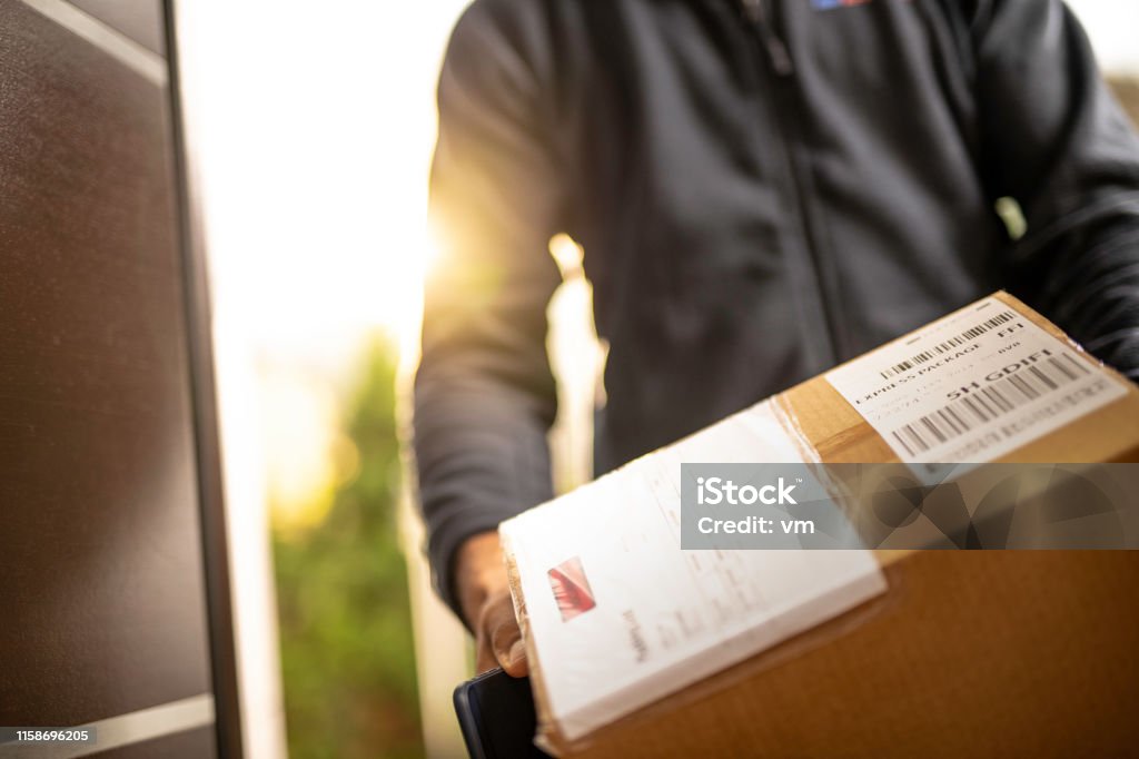 Courier Holding kartonnen doos voor levering - Royalty-free Leveren Stockfoto