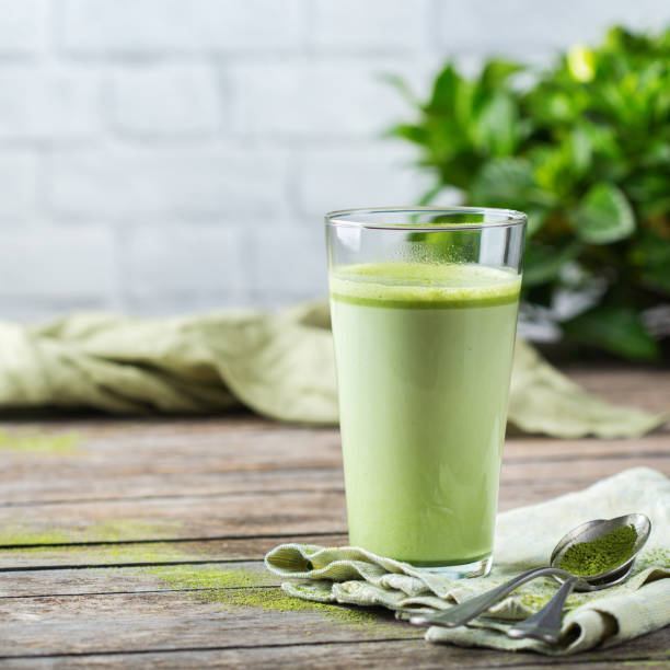 bicchiere di latte di tè verde matcha su un tavolo di legno - powdered coconut foto e immagini stock