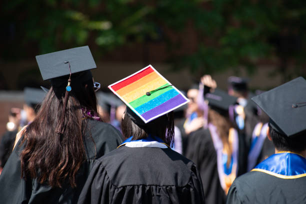 woman wears graduation cap and gown showing gay pride - end of the rainbow imagens e fotografias de stock