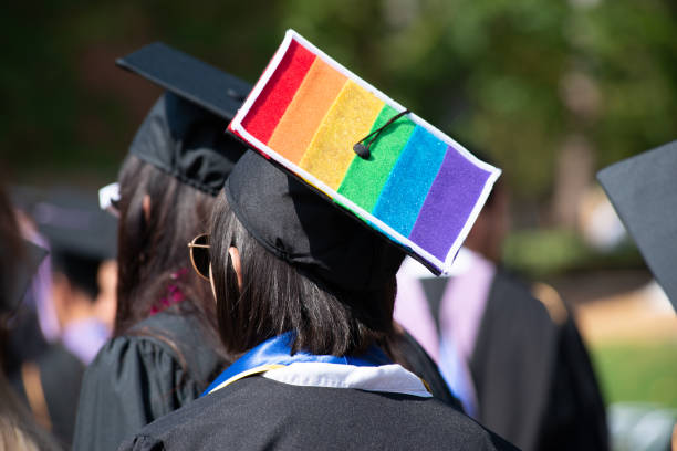 woman wears graduation cap and gown showing gay pride - end of the rainbow imagens e fotografias de stock