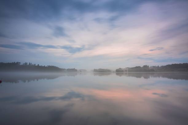 splendida vista della nebbia al tramonto sul lago il giorno d'estate. nuvole bianche sul cielo blu. europa. svezia. sfondi meravigliosi. - peaceful river foto e immagini stock