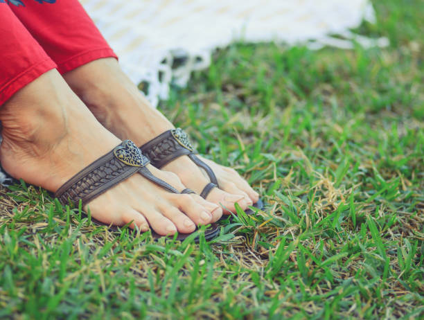 istock Woman’s feet in sandals on the grass 1158697576