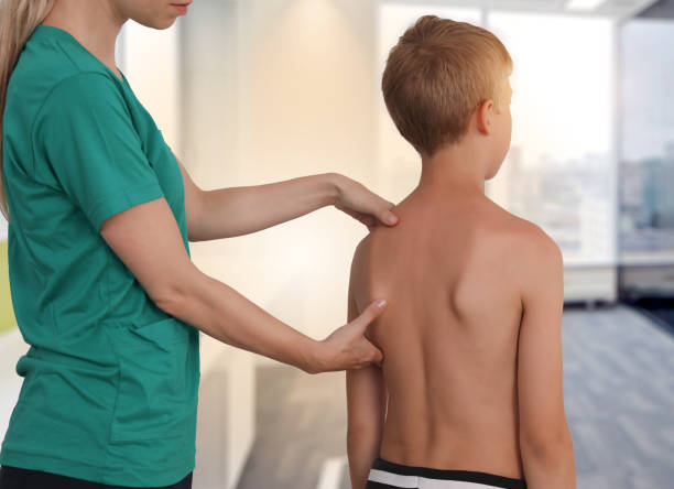 istock Child having chiropractic back adjustment. Osteopathy, Physiotherapy, Kinesiology. Bad posture correction 1158697725