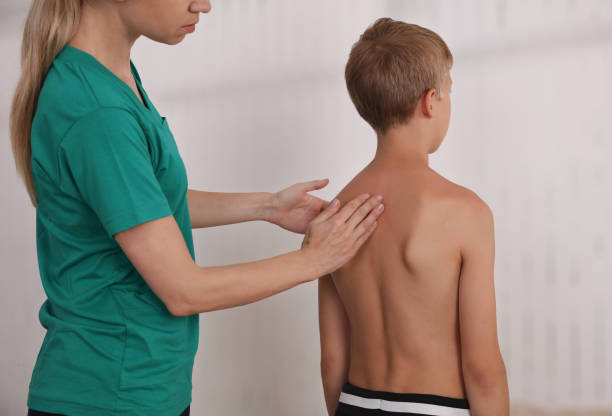 istock Child having chiropractic back adjustment. Osteopathy, Physiotherapy, Kinesiology. Bad posture correction 1158697779