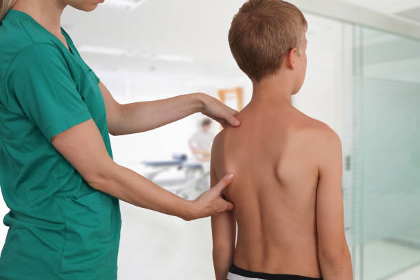 istock Child having chiropractic back adjustment. Osteopathy, Physiotherapy, Kinesiology. Bad posture correction 1158697786