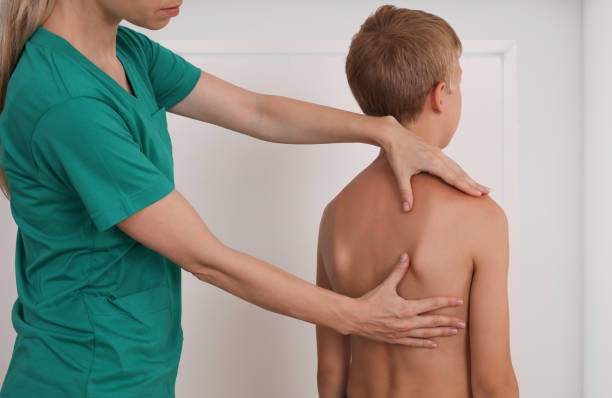 istock Child having chiropractic back adjustment. Osteopathy, Physiotherapy, Kinesiology. Bad posture correction 1158697788