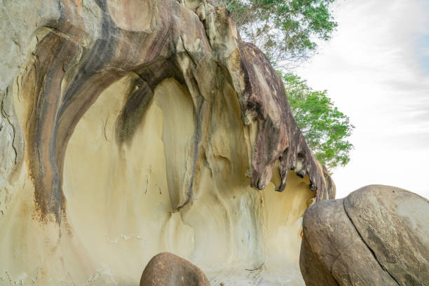 Weathered by the ages, sandstone rock formations and boulders forming intriguing patterns and shapes on coast near Kudat Sabah Borneo.