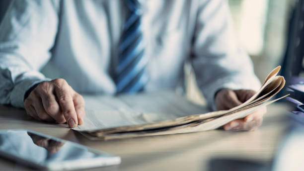 istock Businessman reading the newspaper on table 1158701279