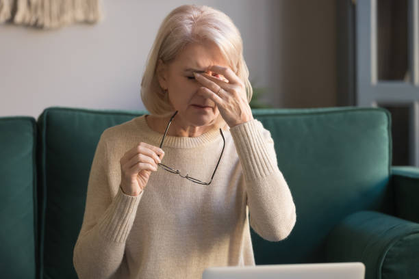 istock Elderly woman taking off glasses tired of computer work 1158702134