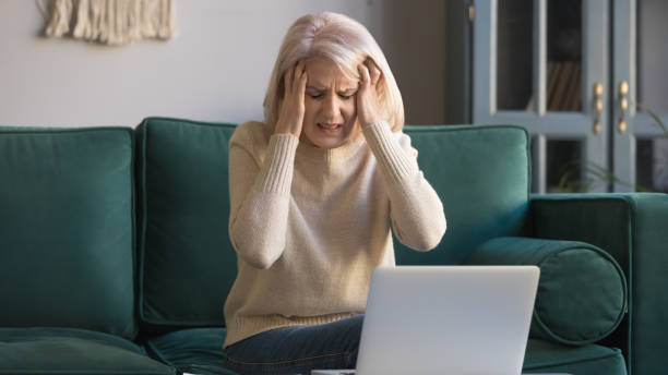 istock Mature woman suffers from headache after long usage of computer 1158702152