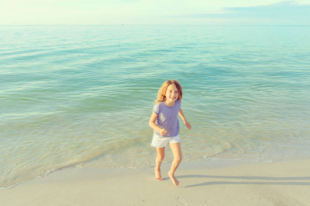 istock Child running along the beach 1158703255