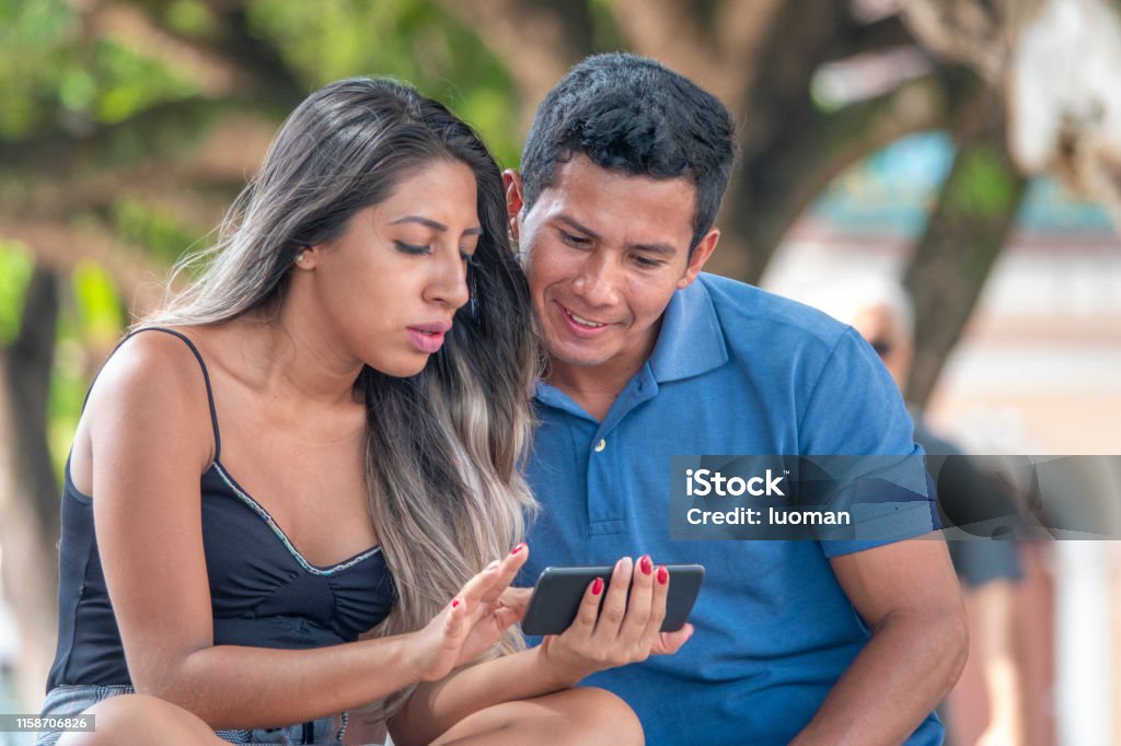 Young couple watching a video in the cell phone Models from the Amazon region.
They are about 24 years old. Amazon Region Stock Photo