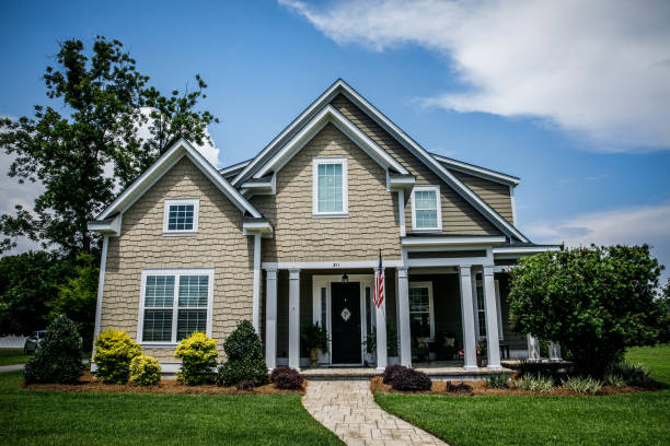istock Large tan new construction home with a walkway in the suburbs 1158712507