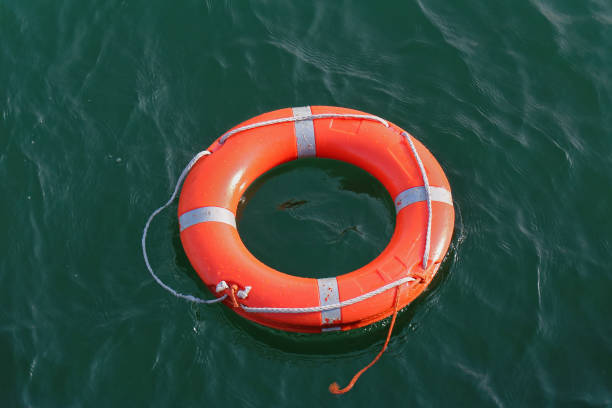 istock Orange circle lifebuoy floating on water 1158716096