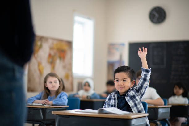 istock Boy raises hand to ask question during lecture in class 1158716673
