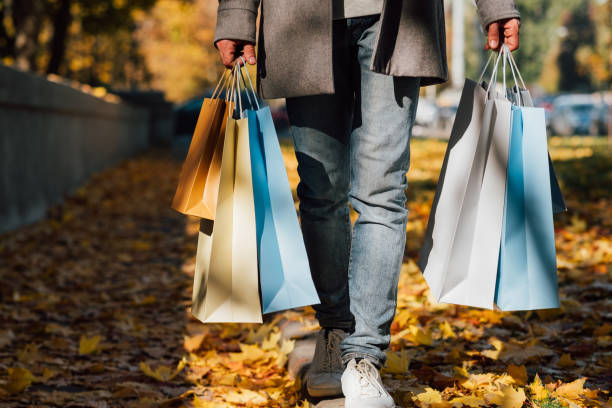 istock autumn shopping man bags fall sidewalk leaves 1158717365