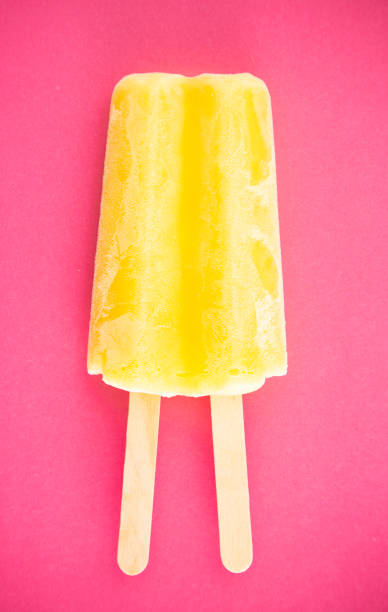 istock Yellow Popsicle on a Bright Pink Background 1158717834