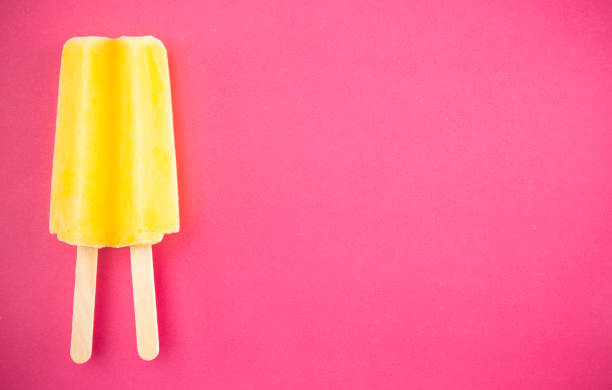 istock Yellow Popsicle on a Bright Pink Background 1158717835