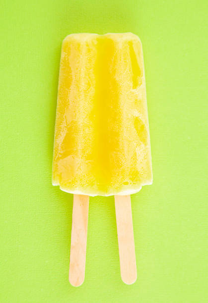 istock Yellow Popsicle on a Bright Green Background 1158717919